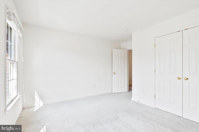 unfurnished bedroom with a closet, baseboards, and carpet floors