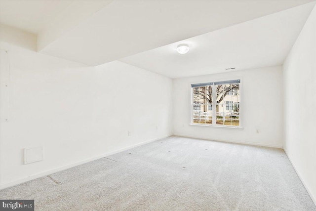 carpeted empty room featuring baseboards