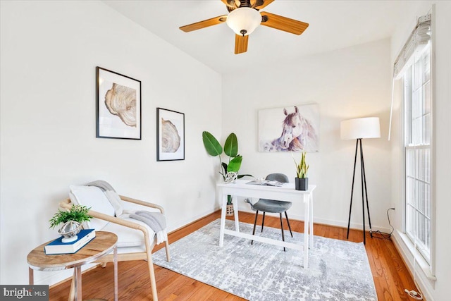 home office featuring a ceiling fan, wood finished floors, and baseboards