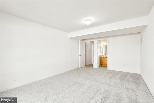 empty room featuring light colored carpet and baseboards