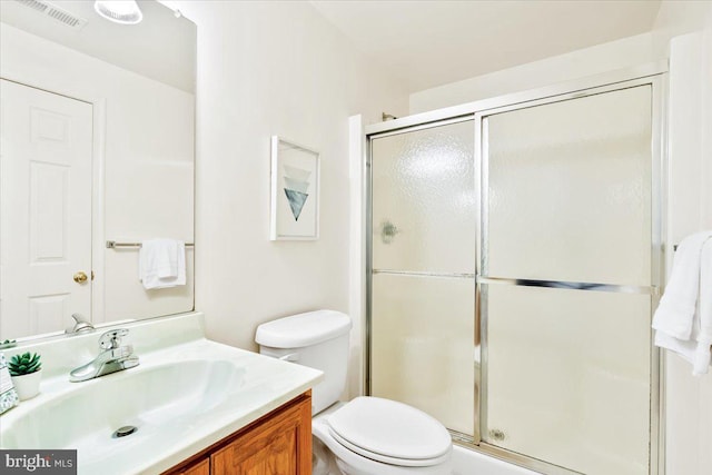 bathroom with visible vents, toilet, a stall shower, and vanity