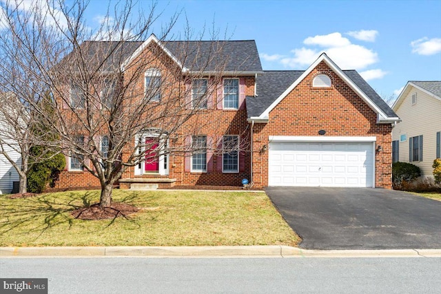 colonial inspired home with brick siding, an attached garage, a shingled roof, a front lawn, and driveway