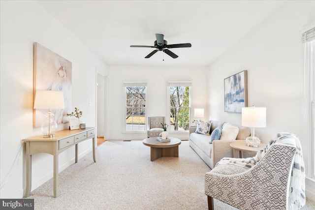 living room featuring baseboards, ceiling fan, and carpet floors