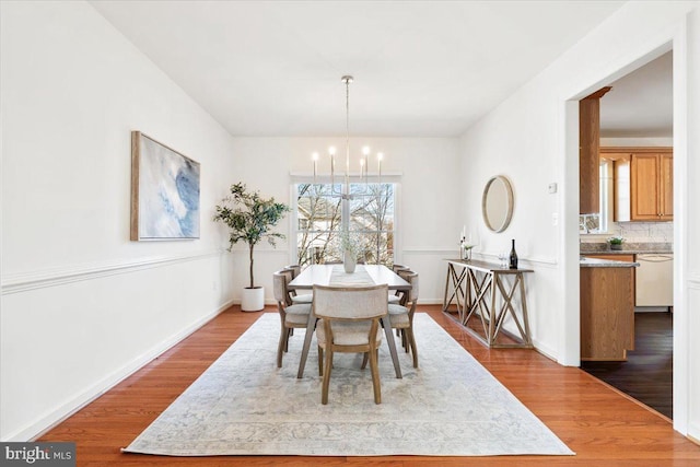 dining area with a notable chandelier and wood finished floors