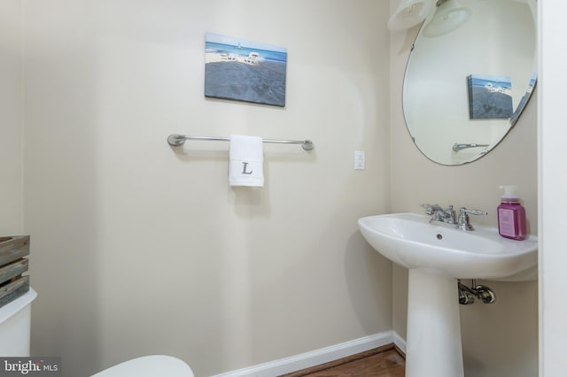 half bath with baseboards and toilet