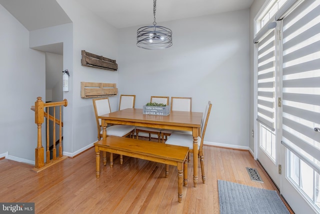 dining space with a notable chandelier, visible vents, light wood-style flooring, and baseboards