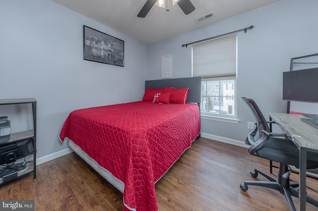 bedroom featuring ceiling fan, wood finished floors, visible vents, and baseboards