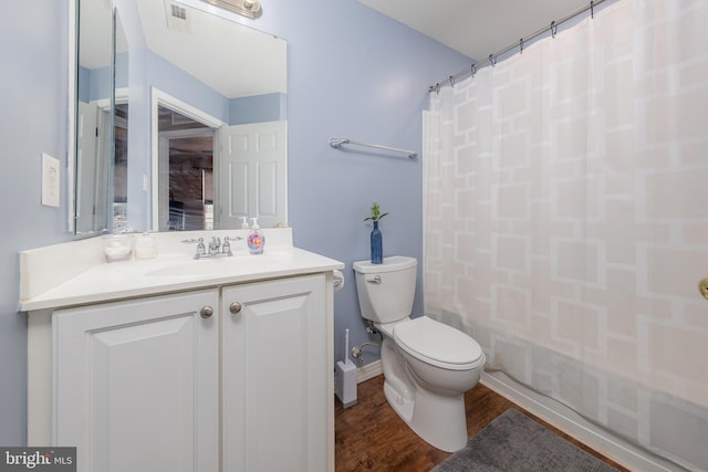 bathroom with visible vents, baseboards, toilet, wood finished floors, and vanity