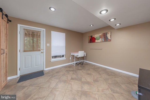 interior space featuring a barn door, light tile patterned floors, recessed lighting, and baseboards