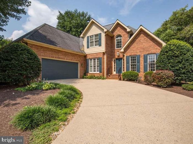 traditional-style house featuring a garage, brick siding, and concrete driveway