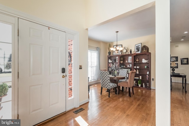 entryway with visible vents, a chandelier, and light wood-style flooring