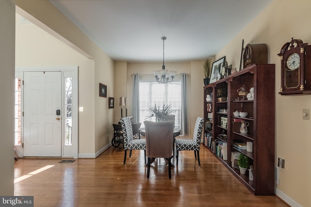 dining room with an inviting chandelier, wood finished floors, and baseboards