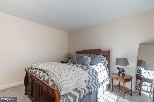 bedroom featuring light carpet and baseboards