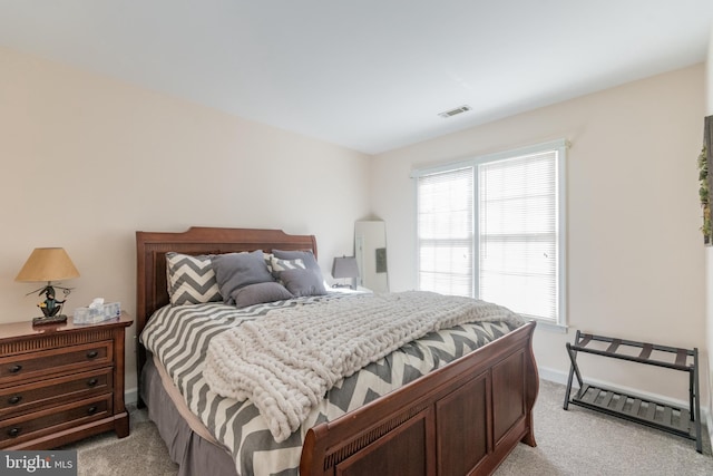 bedroom with visible vents, baseboards, and light colored carpet