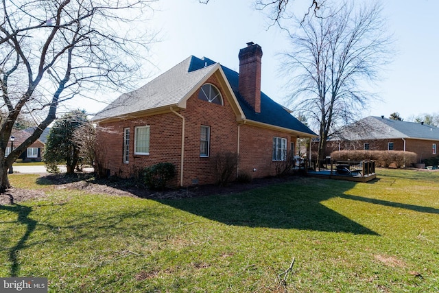 view of property exterior with brick siding, a wooden deck, a lawn, and a chimney