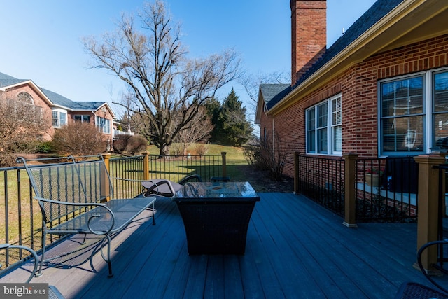 wooden deck featuring a lawn