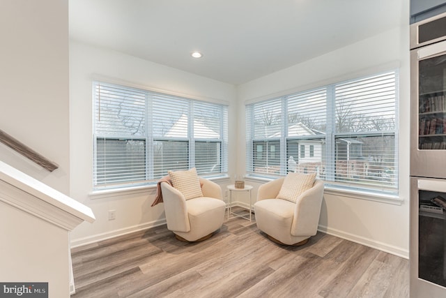 living area with light wood-style flooring, baseboards, beverage cooler, and recessed lighting