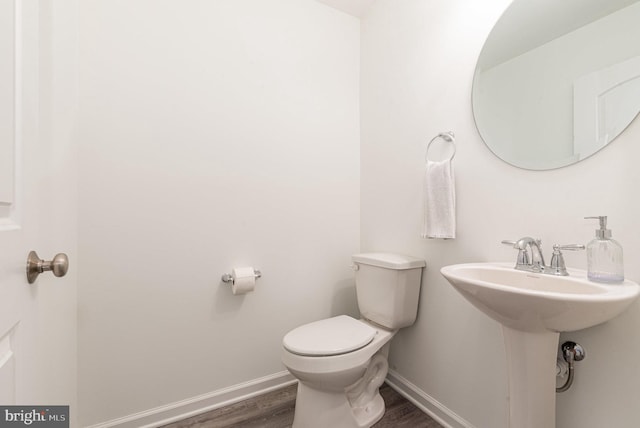 bathroom featuring wood finished floors, toilet, and baseboards