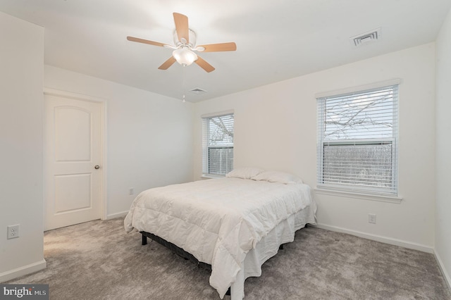 carpeted bedroom with visible vents, ceiling fan, and baseboards