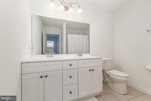 full bathroom featuring double vanity, tile patterned flooring, a sink, and toilet