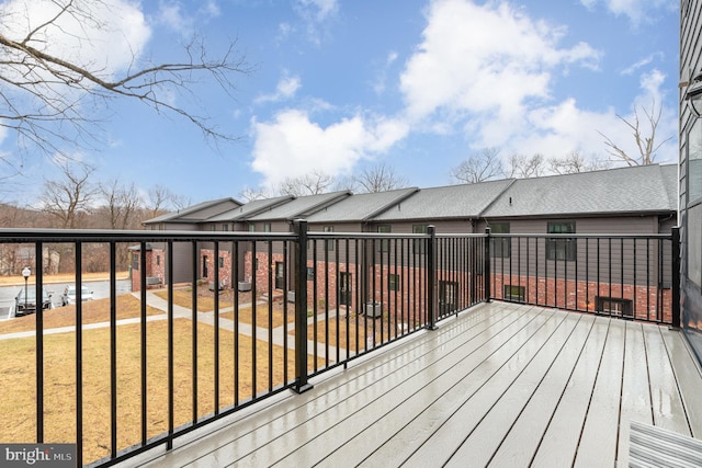 wooden terrace featuring a lawn