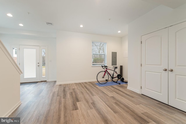 foyer entrance with light wood finished floors, recessed lighting, visible vents, electric panel, and baseboards