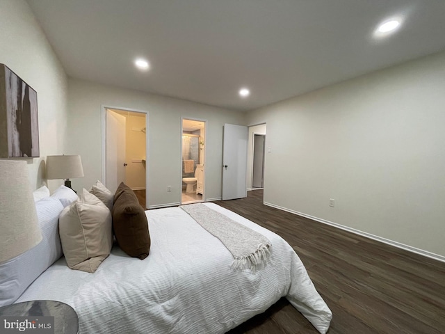 bedroom featuring recessed lighting, a spacious closet, ensuite bathroom, dark wood-type flooring, and baseboards