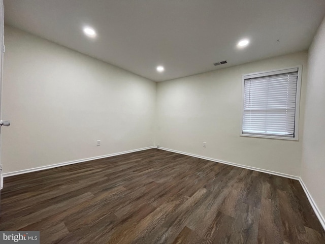 unfurnished room with dark wood-style floors, baseboards, visible vents, and recessed lighting