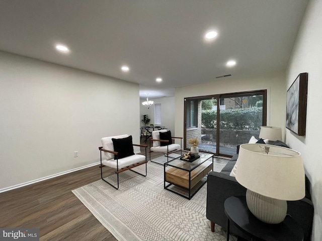 living area with recessed lighting, a notable chandelier, baseboards, and wood finished floors