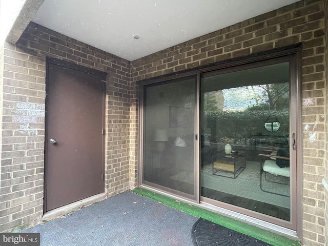 property entrance featuring brick siding