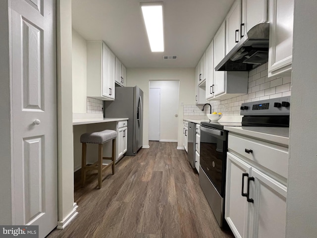 kitchen featuring visible vents, dark wood-style floors, appliances with stainless steel finishes, light countertops, and under cabinet range hood