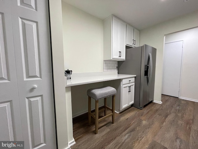 kitchen with white cabinets, dark wood-style floors, tasteful backsplash, and stainless steel refrigerator with ice dispenser