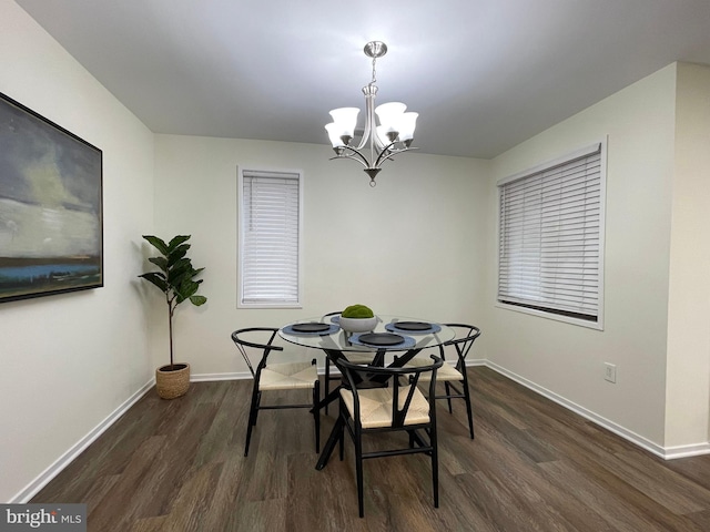 dining room featuring dark wood-style floors, an inviting chandelier, and baseboards