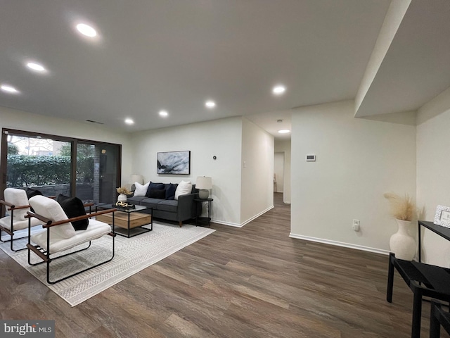 living area featuring recessed lighting, dark wood finished floors, and baseboards