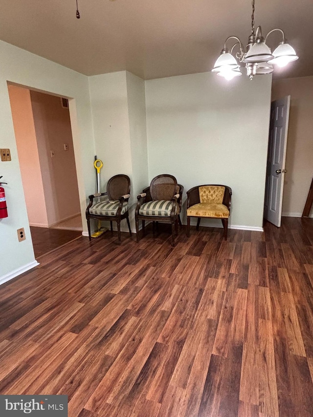 sitting room with an inviting chandelier, baseboards, and wood finished floors