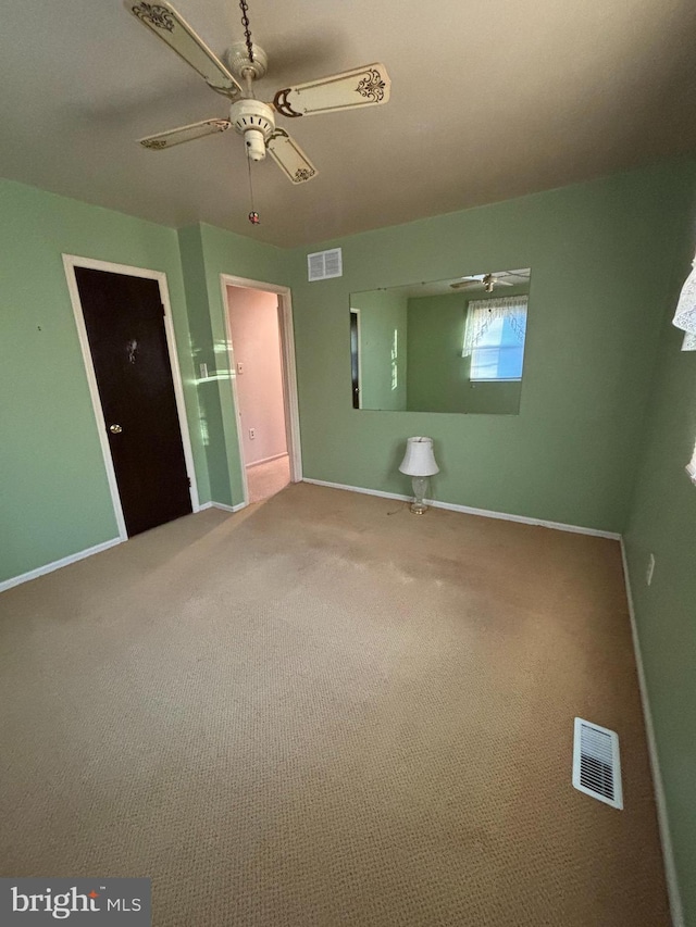 unfurnished bedroom with carpet, visible vents, and baseboards