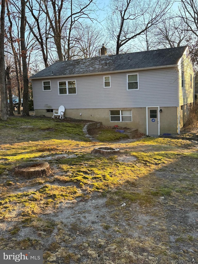 back of house with a chimney