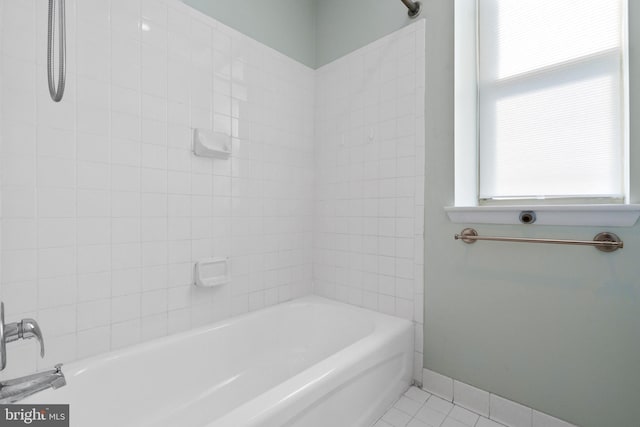 full bathroom featuring a healthy amount of sunlight, bathtub / shower combination, baseboards, and tile patterned floors