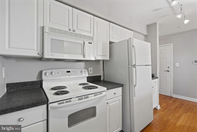 kitchen featuring white appliances, white cabinets, light wood-type flooring, dark countertops, and rail lighting