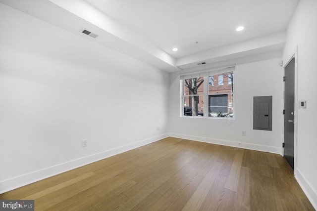 spare room with recessed lighting, wood finished floors, visible vents, baseboards, and electric panel