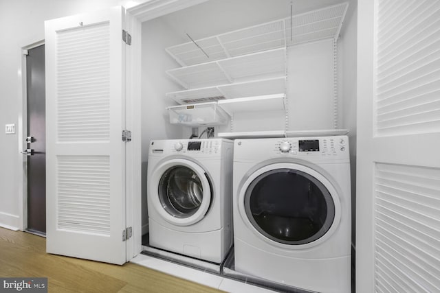 laundry area with laundry area, independent washer and dryer, and wood finished floors