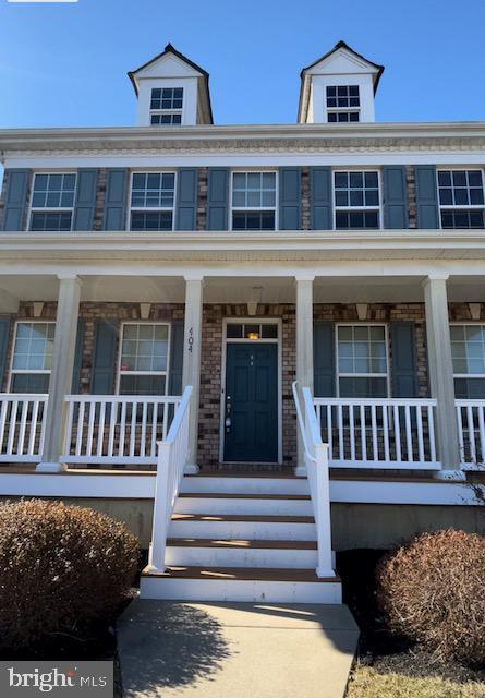 view of front of house with covered porch and brick siding