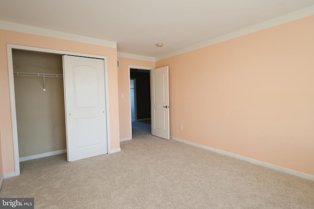 unfurnished bedroom featuring a closet, carpet, and baseboards