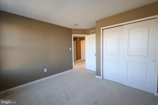 unfurnished bedroom with light colored carpet, a closet, visible vents, and baseboards