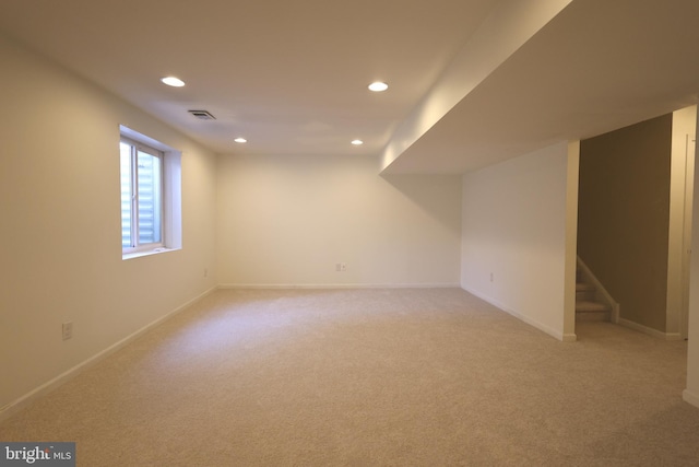 basement featuring recessed lighting, light carpet, visible vents, baseboards, and stairs