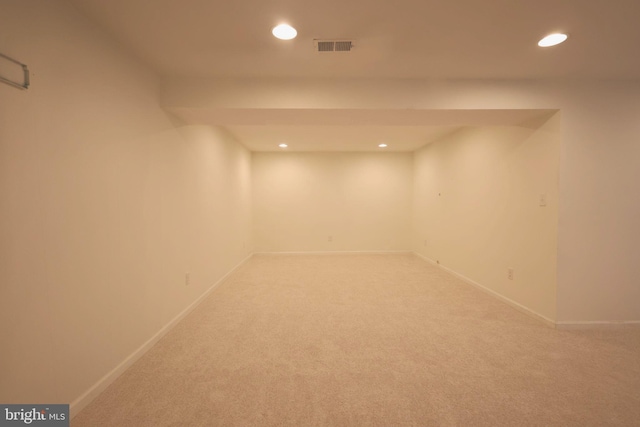 finished below grade area featuring light carpet, baseboards, visible vents, and recessed lighting