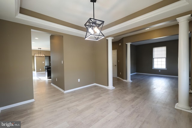 empty room with ornamental molding, light wood-type flooring, decorative columns, and baseboards