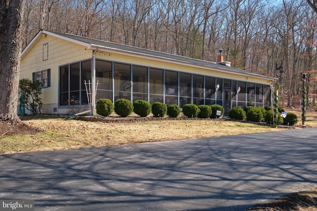 view of front facade with a chimney and a sunroom