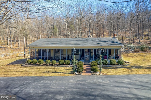 view of front of property with a sunroom, a front lawn, and a porch