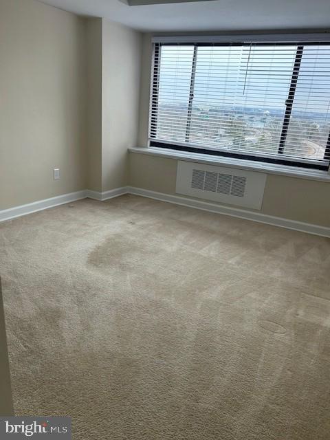 carpeted spare room with baseboards and visible vents